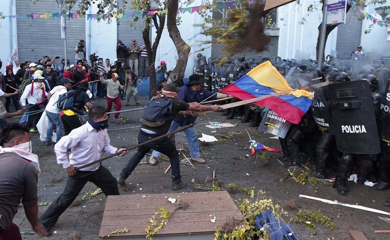 Demonstrators clash with police during a march in Quito