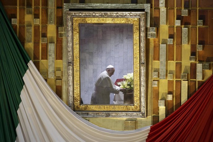 Pope Francis is seen praying in front of the image of Our Lady of Guadalupe whil