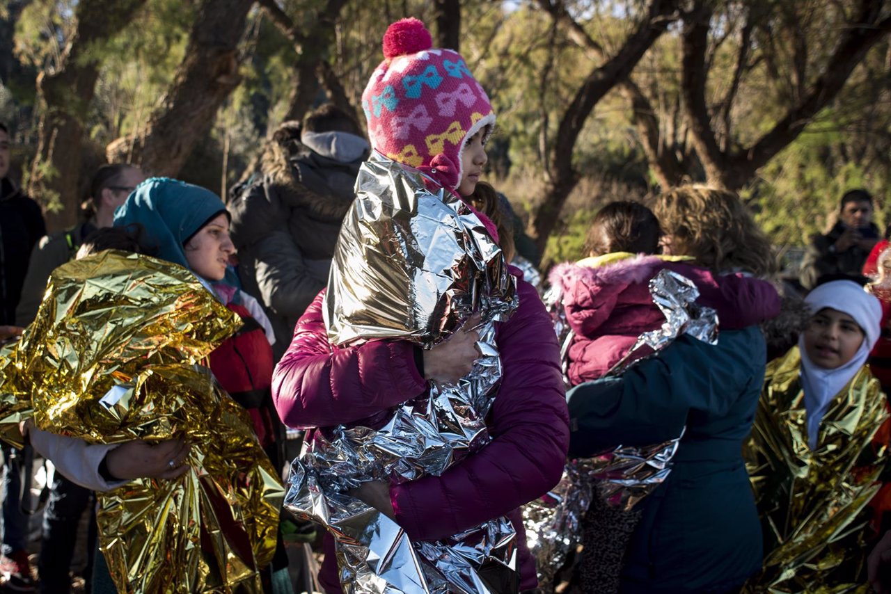 Niños refugiados con sus madres tras llegar a Lesbos