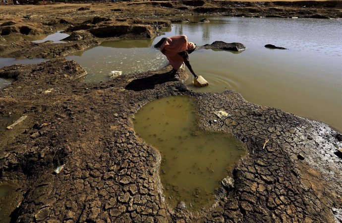 Una desplazada interna recoge agua en Darfur Norte (Sudán)