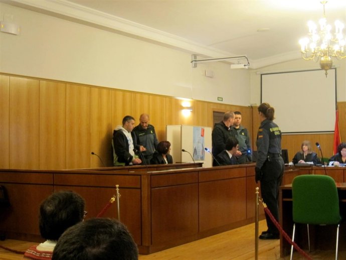 Los acusados, junto a agentes de la Guardia Civil, al inicio del juicio. 
