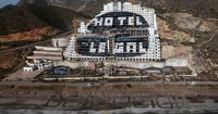 Activistas de Greenpeace escriben 'Demolición' ante el hotel de El Algarrobico