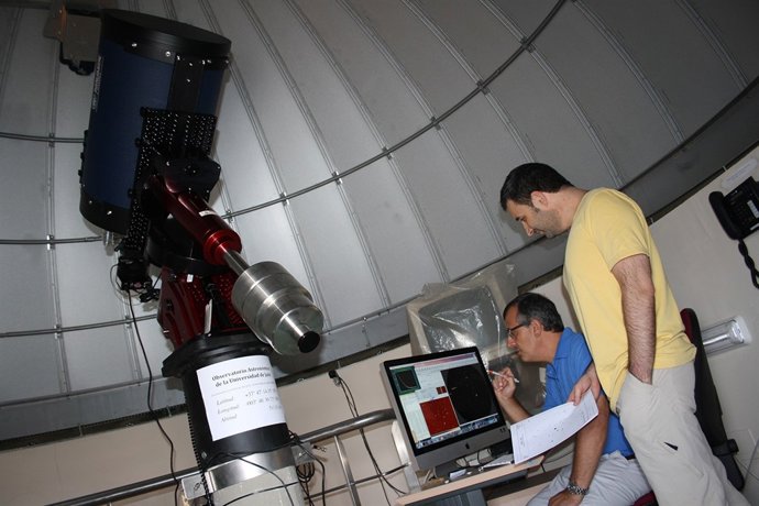 Dos investigadores de la UJA manejan el telescopio.