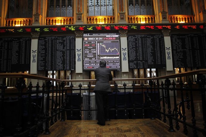 A trader looks at an electronic board showing the Ibex35 during trading at the M