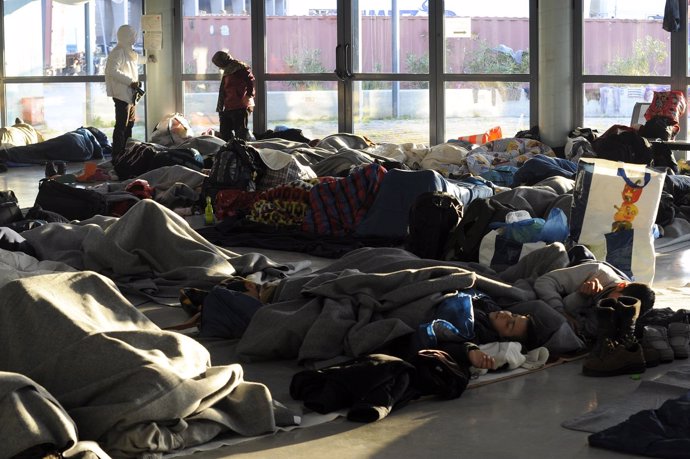 Un grupo de refugiados duermen en la terminal del puerto de Pireo, en Grecia