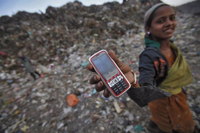 Una niña india muestra su teléfono móvil
