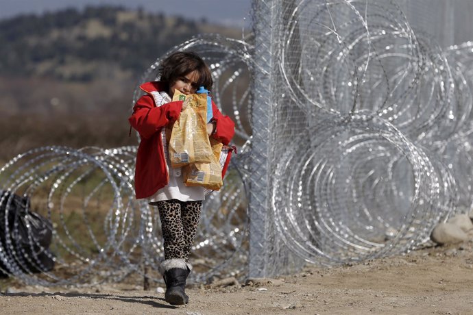 Nina afgana en la alambrada en la frontera entre Grecia y Macedonia