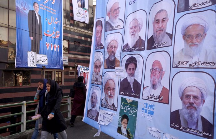 Mujeres junto a un cartel electoral en Teherán