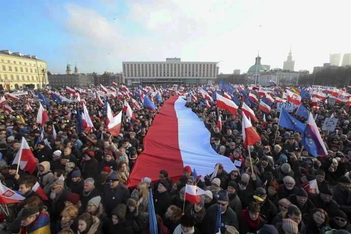 People hold EU and Polish national flags during a demonstration in Warsaw