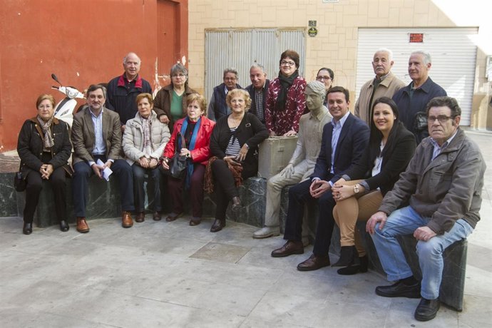 Los diputados y los miembros de Asaler junto a la estatua del emigrante.