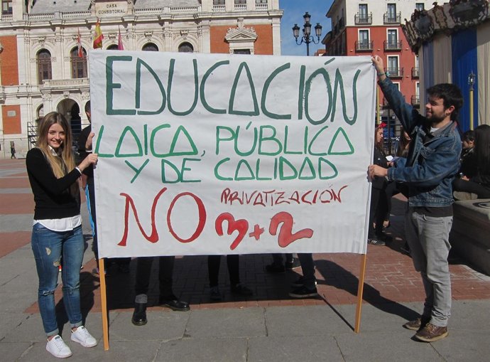 Dos de los manifestantes sostienen una pancarta