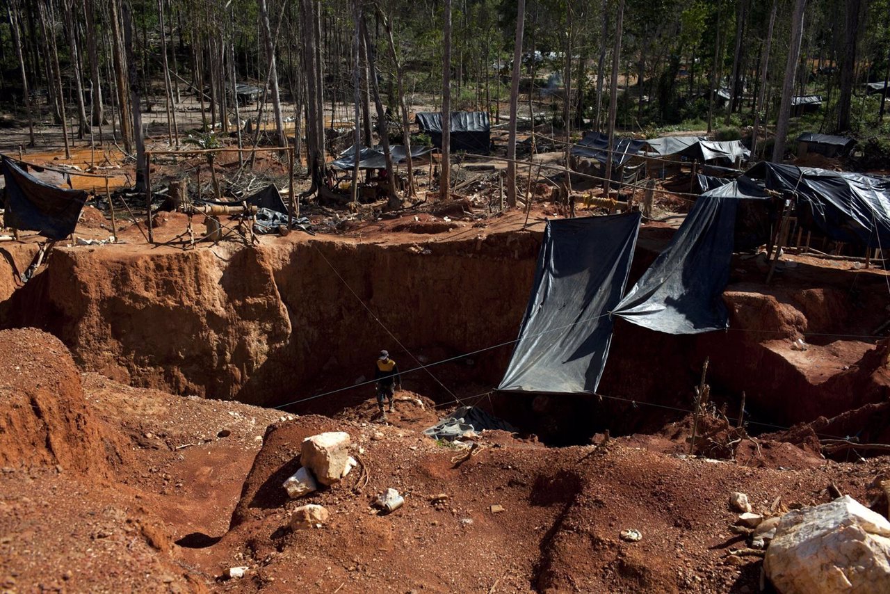 An illegal gold miner looks for gold at a makeshift camp for illegal mining near