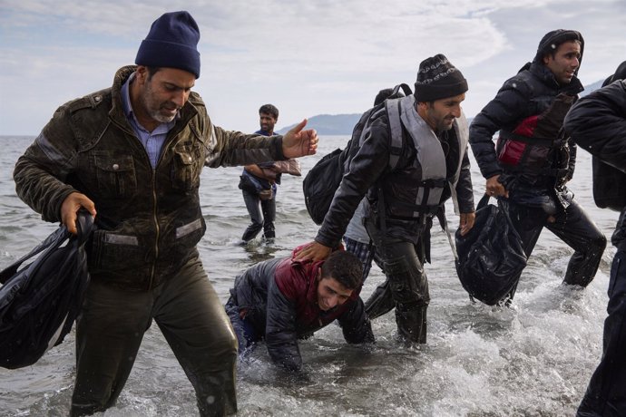 Refugiados desembarcando de una lancha en la costa de Lesbos (Grecia)