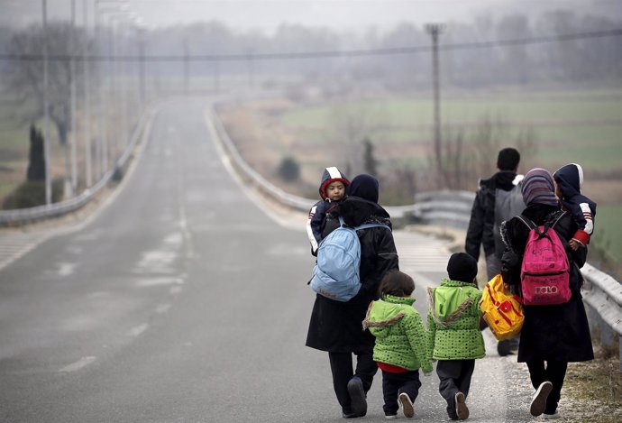 Una familia de inmigrantes afganos camina por una carretera en Grecia