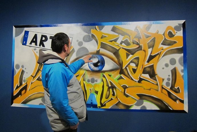 Uno de los participantes en la exposición explica su obra 