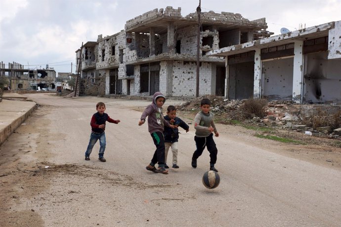 Niños juegan en medio de una localidad de Deraa arrasada por la guerra