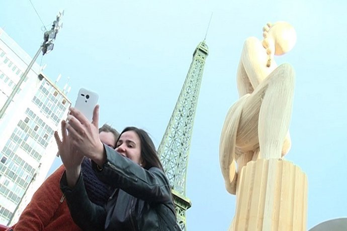 Dos jóvenes se fotografían ante la falla municipal 
