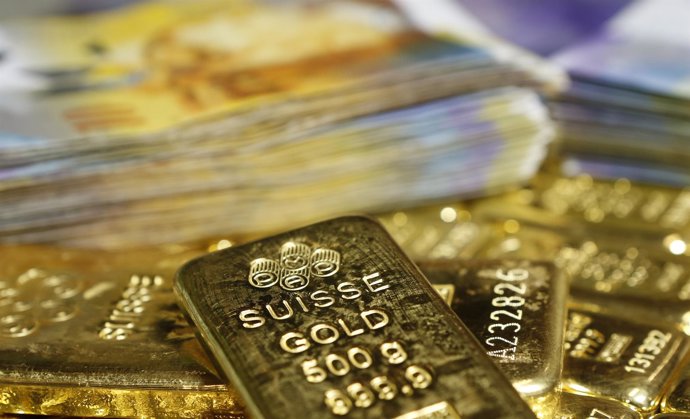 Gold bars and Swiss Franc banknotes are seen in this illustration picture in Vie