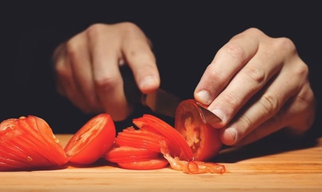 Hombre cortando tomates