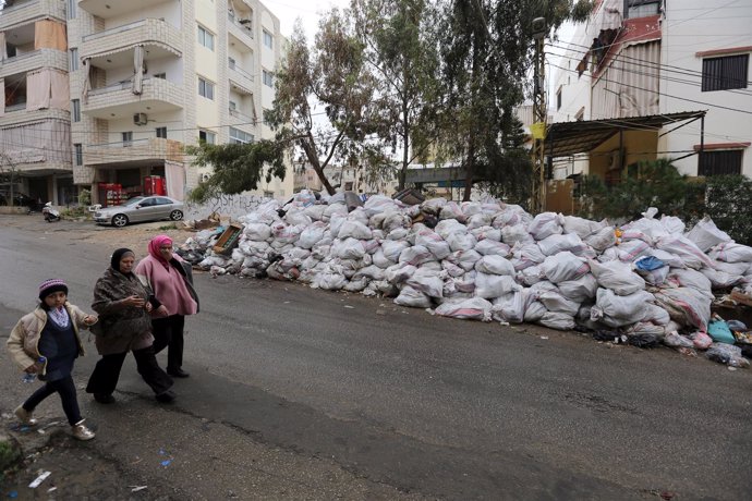 Residents walk near packed garbage in Wadi al-Zayneh, Chouf district
