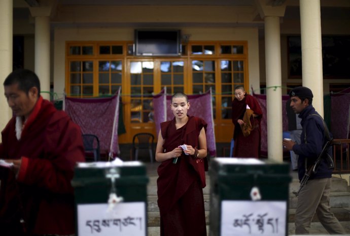 A Tibetan nun walks towards the ballot box to cast her vote during the election 