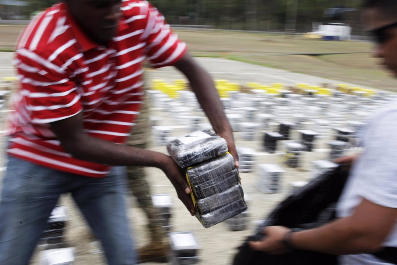 A member of the Aero Naval police carries packages of seized cocaine during a dr