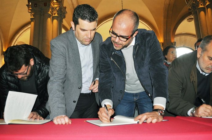 X. Amor (FMC) y M. Buch (ACM) firman el libro de condolencias