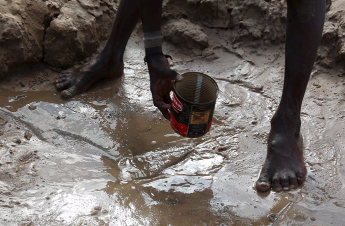 Un niño recoge agua de un río seco en la region de Shabelle (Somalia)