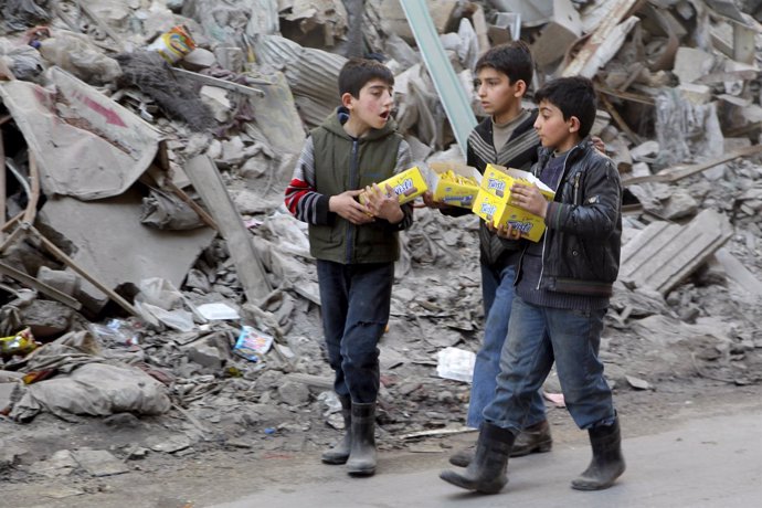 Niños caminan entre escombros en Alepo (Siria)