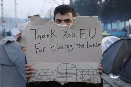 Refugiado con un cartel en Idomeni