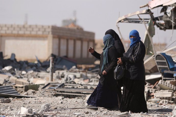 Mujeres caminan entre escombros en la provincia de Hasaka (Siria)