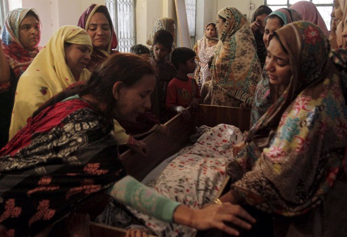 Familiares velando a una víctima del atentado de Lahore