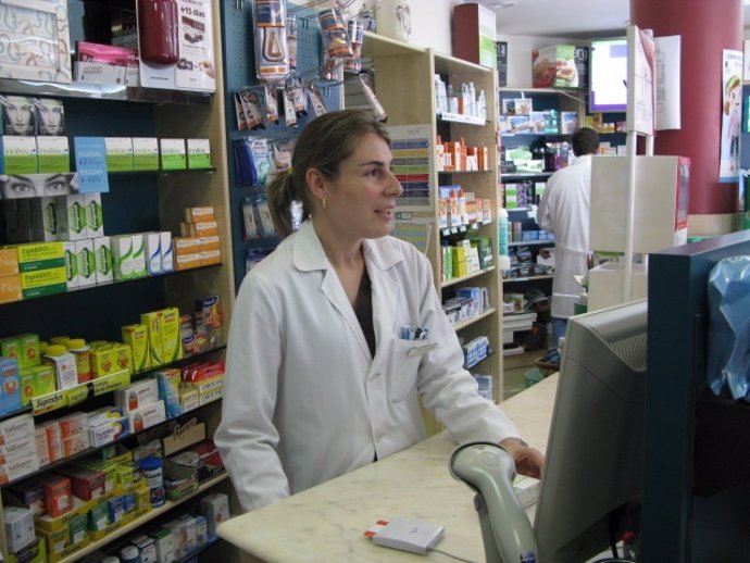 Una farmacéutica atiende a los clientes.
