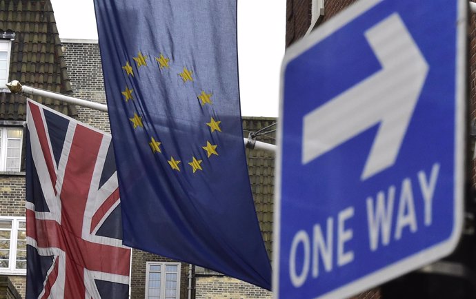 Bandera de Reino Unido y la UE junto a señal de 'one way'