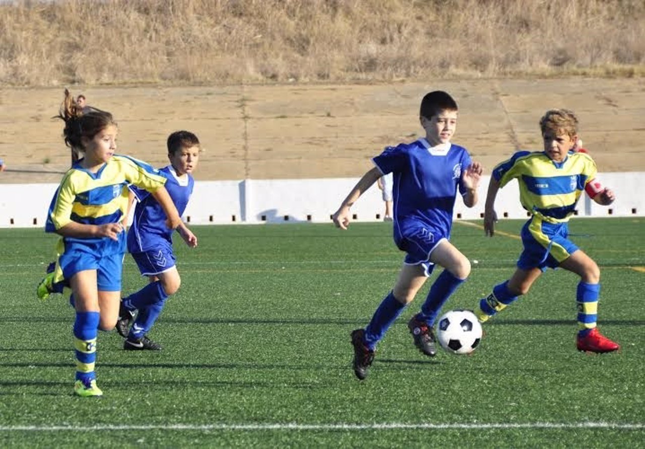 Niños jugando al fútbol en Huelva.