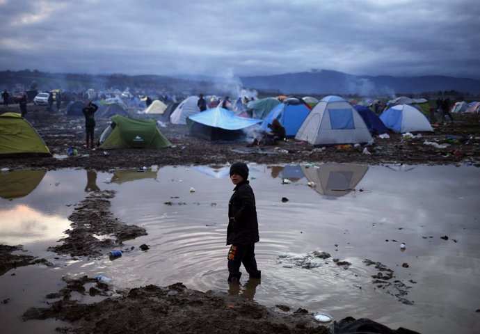 Un niño inmigrante en medio de un charco en Idomeni