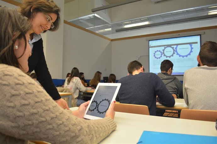 La profesora María Eugenia Sánchez observando junto a una alumna los apuntes