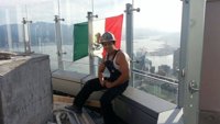 Un hombre coloca una bandera de México en lo alto de la Torre Trump en Canadá