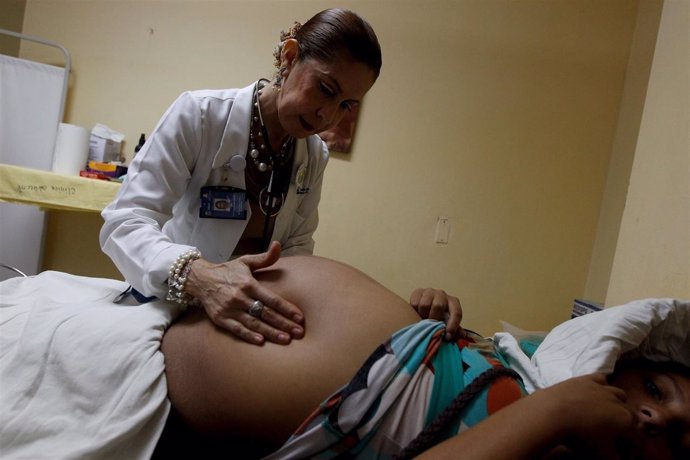 Doctor performs a routine general check up for a pregnant woman, which includes 