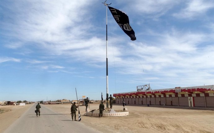 Las fuerzas de Irak arrían una bandera de Estado Islámico cerca de Ramadi