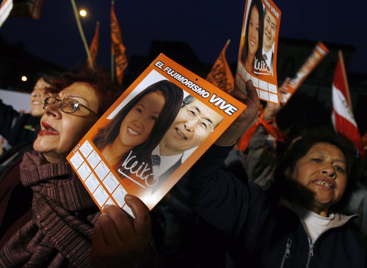Supporters of former Peruvian President Fujimori hold pictures of him and his da