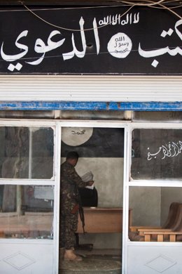 Un miliciano revisa una oficina de apoyo a Estado Islámico en Raqqa