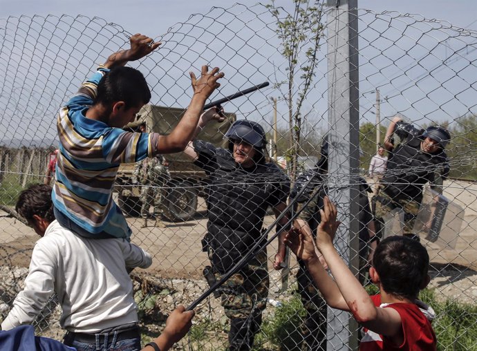 Policía macedonio cargando contra inmigrantes en la frontera con grecia