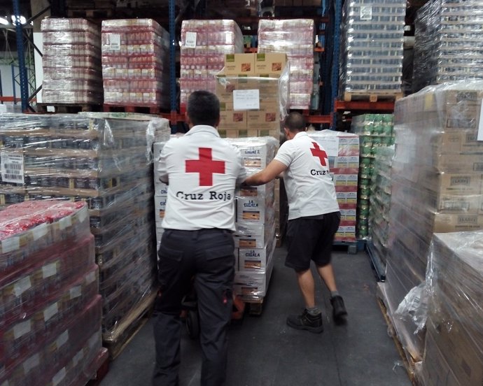 Imagen de unos voluntarios de Cruz Roja con los alimentos