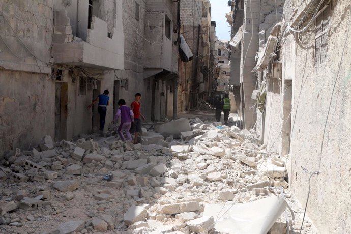Residentes inspeccionan daños tras un bombardeo aéreo en un barrio de Alepo
