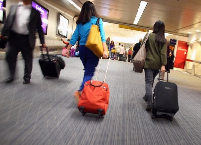 Pasajeros con maleta en aeropuerto 