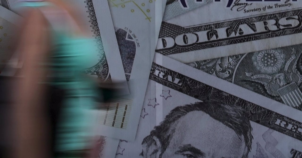 A woman walks past a currency exchange office in Sao Paulo