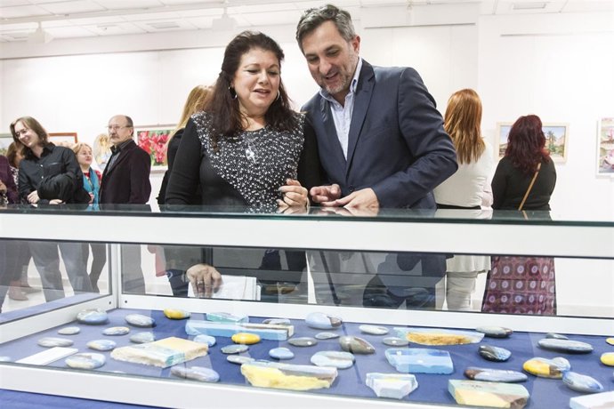 El diputado Ángel Escobar observando las piedras pintadas de Pilar Gallego.