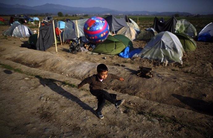 Un niño juega con una pelota en el campamento de refugiados de Idomeni