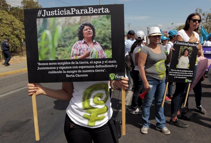 An activist holds a photos of slain environmental rights activist Berta Caceres 